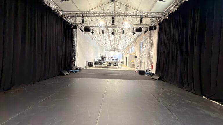 Armazém da Show Reel com estrutura de trussing e cortinas negras para montagem de set, em Lisboa